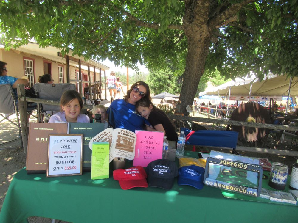 Photo of Kelly and her children at the table in the shade