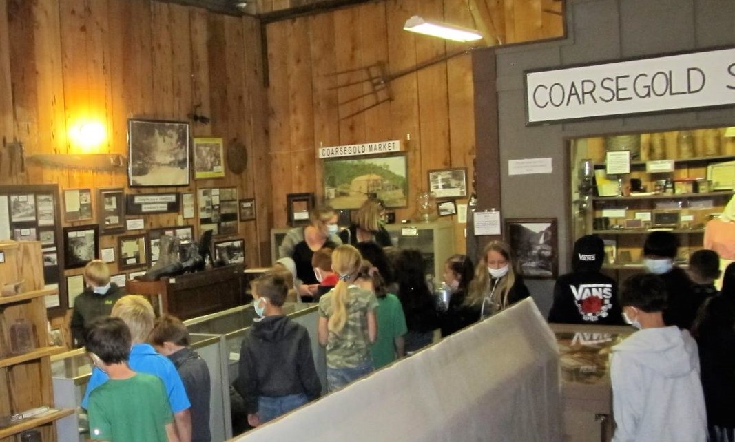 This is a photo of the school children looking at the exhibits inside the Barn. 